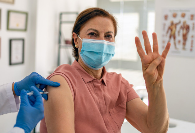 mujer recibiendo cuarta dosis vacuna covid