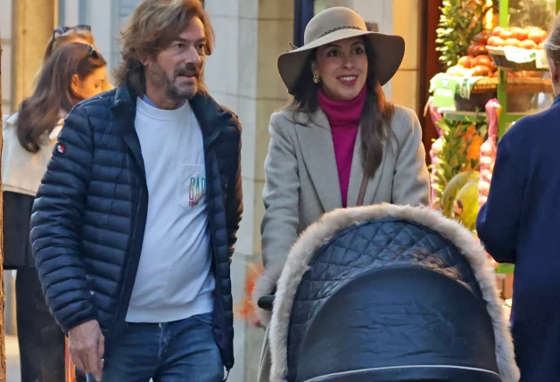 Elena Hormigos y Santiago Pedraz paseando con su bebé.