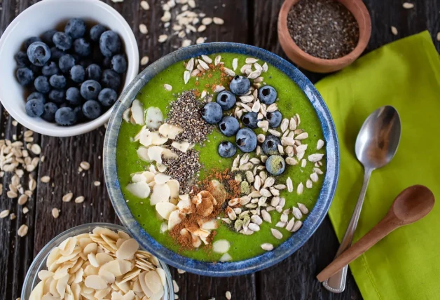 Tazón de batido verde con almendras, arándanos, chía y semillas de girasol