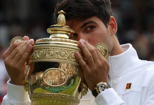 Carlos Alcaraz besa su trofeo en Wimbledon.