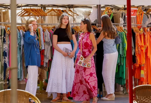 La princesa Leonor, la reina Letizia, la infanta Sofía y la reina emérita Sofía comprando ropa en un mercadillo.