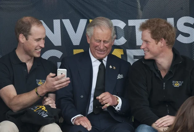 Carlos de Inlgaterra riendo junto a los príncipes Guillermo y Harry.