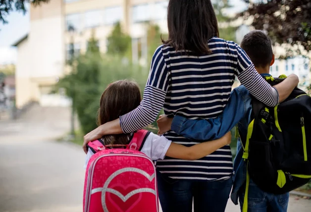 Madre acompaña a sus hijos al colegio