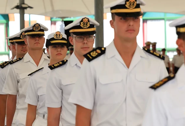 La princesa vestida con el uniforme oficial de la escuela naval, formando en fila india entre sus compañeros