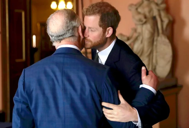 El rey Carlos de Inglaterra y su hijo Harry dándose un beso