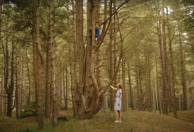 Kate Middleton vigilando a us hijo, que escala un árbol en un bosque.