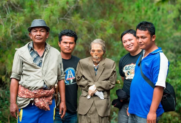 Indonesios posan con un familiar muerto.