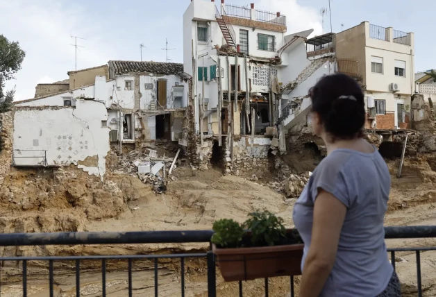 Una mujer observa varias casas dañadas en Chiva tras la DANA.