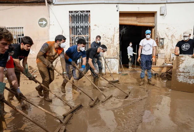 Voluntarios desalojando agua de las calles de Valencia.