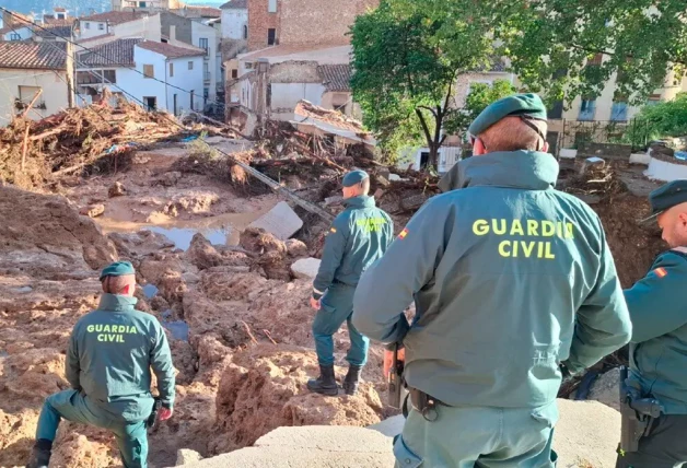 Guardias Civiles mirando las ruinas de un edificio afectado por la inundación.