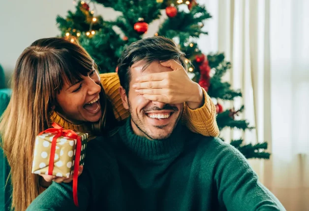 Mujer sorpendiendo con un regalo a su pareja