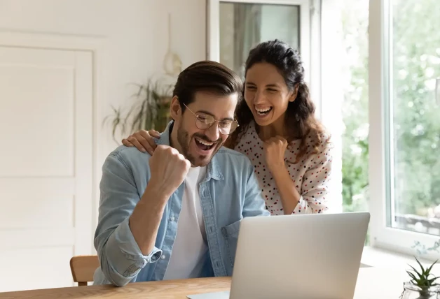 Pareja celebrando juntos su éxito.