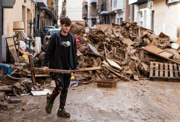 Chico recogiendo escombros en Valencia.