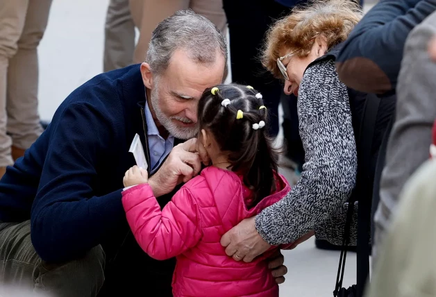 El rey Felipe con una niña durante su visita a la localidad valenciana de Chiva este martes.