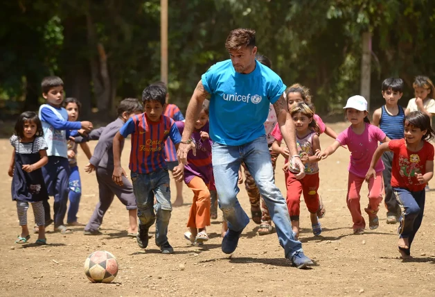 Ricky Martin jugando a fútbol con niños víctimas de la explotación infantil.