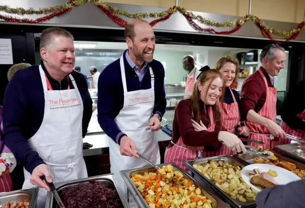 El príncipe Guillermo de Inglaterra colaborando como voluntario en un comedor social.