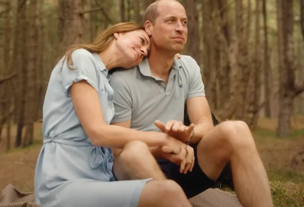 El Príncipe Guillermo y Kate Middleton abrazados en un bosque.