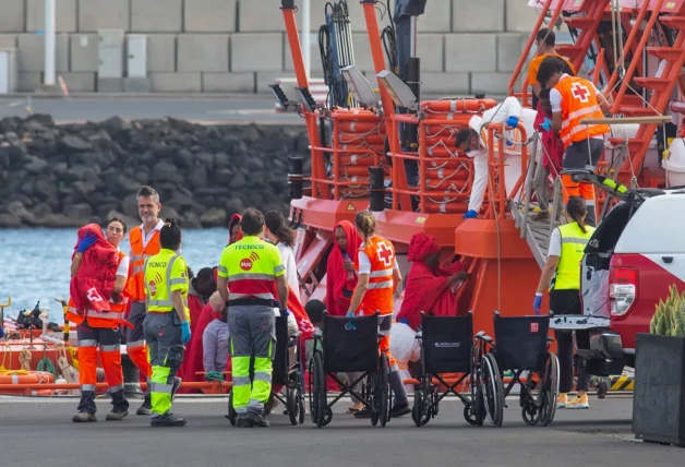 Los trabajadores de salvamento marítimo y de la cruz roja ayudando a los refugiados llegados en patera.