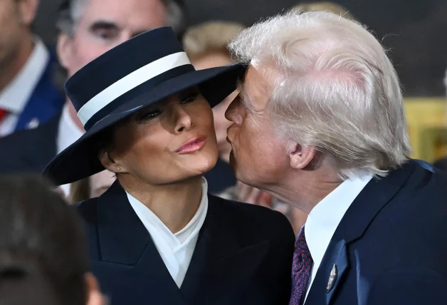 Melania Trump y Donald Trump dándose un beso.