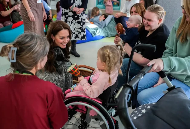 Kate Middleton saludando a una niña en silla de ruedas.