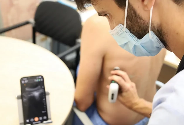 Doctor haciendo una prueba en un paciente para detectar señales de neumonía.