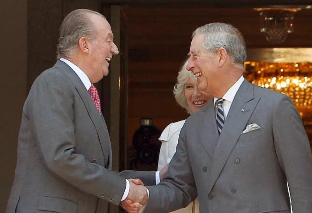 Juan Carlos I saludando a Carlos III en 2011.