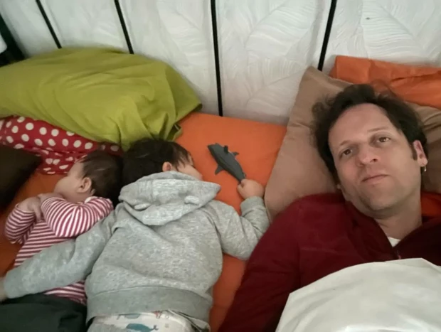 Edu Soto tumbado en la cama con sus hijos.