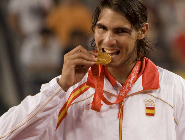 PEKÍN (CHINA) 17/8/2008.- El tenista español Rafael Nadal muerde la medalla de oro tras vencer al chileno Fernando González en la final masculina individual de tenis de los Juegos Olímpicos de Pekín 2008, en el Centro Olímpico de Tenis de Pekin, China, hoy 17 de agosto de 2008. Nadal venció 6-3, 7-6 (2) y 6-3. EFE/Adrian Bradshaw