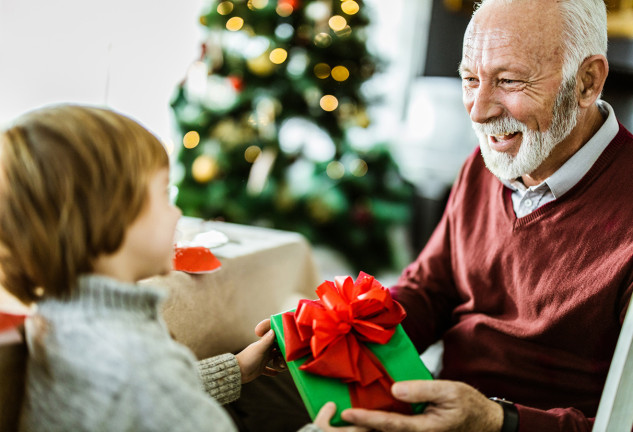 Niño dando un regalo a su abuelo con alzheimer.