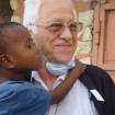 El padre Ángel sosteniendo en brazos a un niño del programa NUPAilusión.