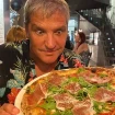 Gustavo González comiendo pizza.