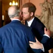 El rey Carlos de Inglaterra y su hijo Harry dándose un beso