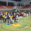 Personas refugiadas comiendo en la pista del polideportivo.