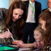 Kate Middleton pintando de rojo la mano de una niña enferma en un hospital.