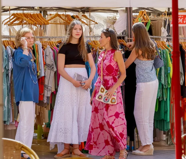 Letizia con sus hijas y la reina sofía mirando vestidos en un mercadillo de Mallorca.