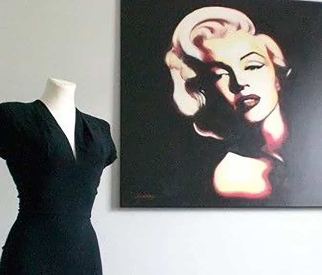 Uno de sus vestidos junto a un retrato de Marilyn Monroe