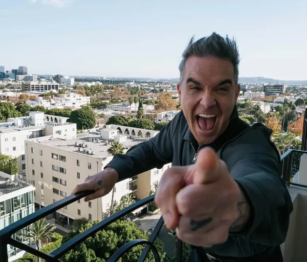 Robbie Williams bromeando en un balcón con vistas