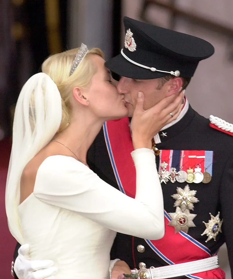 Haakon y Mette-Marit besándose en el balcón de palacio el día de su boda.