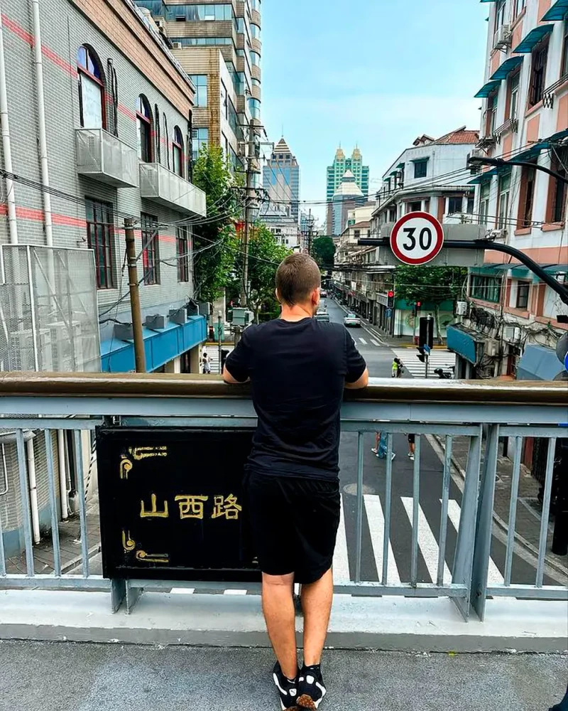 Niño asomado a un puente en una ciudad china