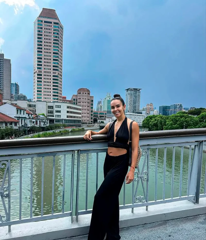 Cristina Pedroche posando apoyada en la barandilla de un puente sobre un río en una ciudad china.