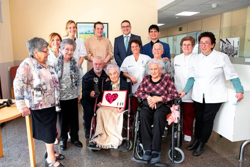 María Branyàs posando con otros ancianos en una residencia