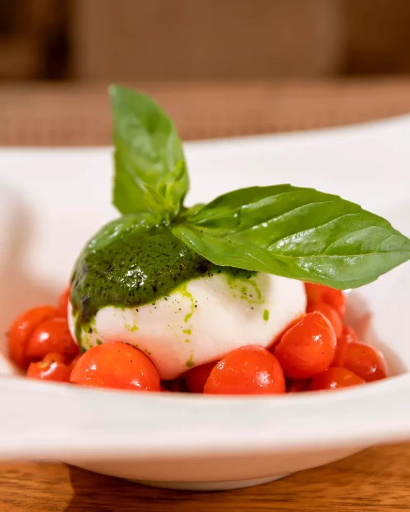 Ensalada Caprese con mozzarella, tomate y albahaca.