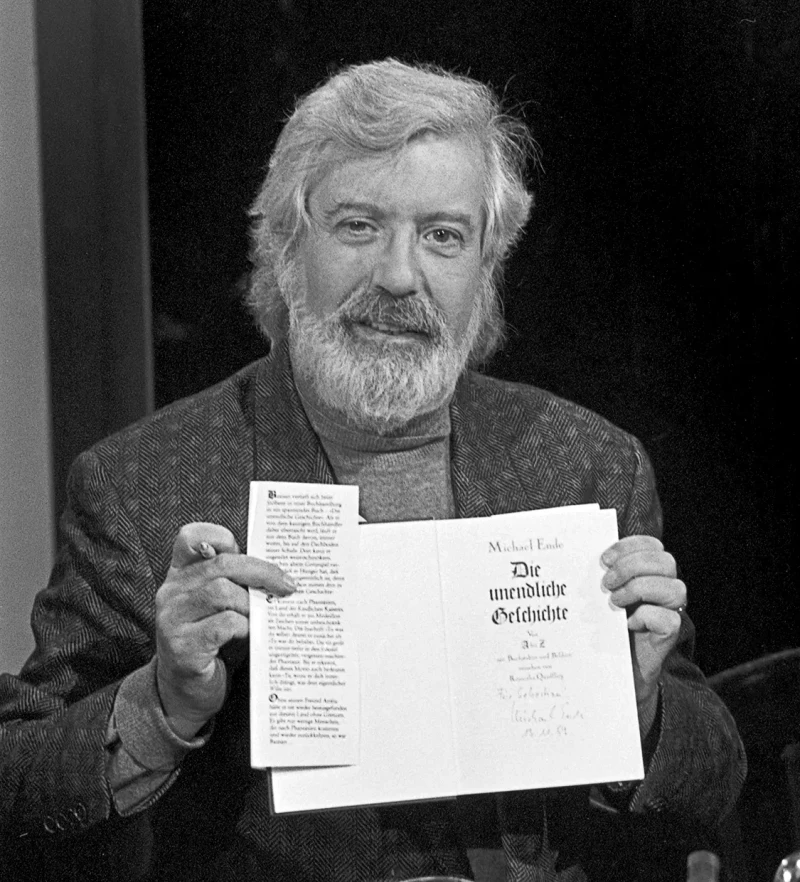 Michael Ende mostrando la primera página de la primera edición en alemán de su obra más célebre, 'La historia interminable'.