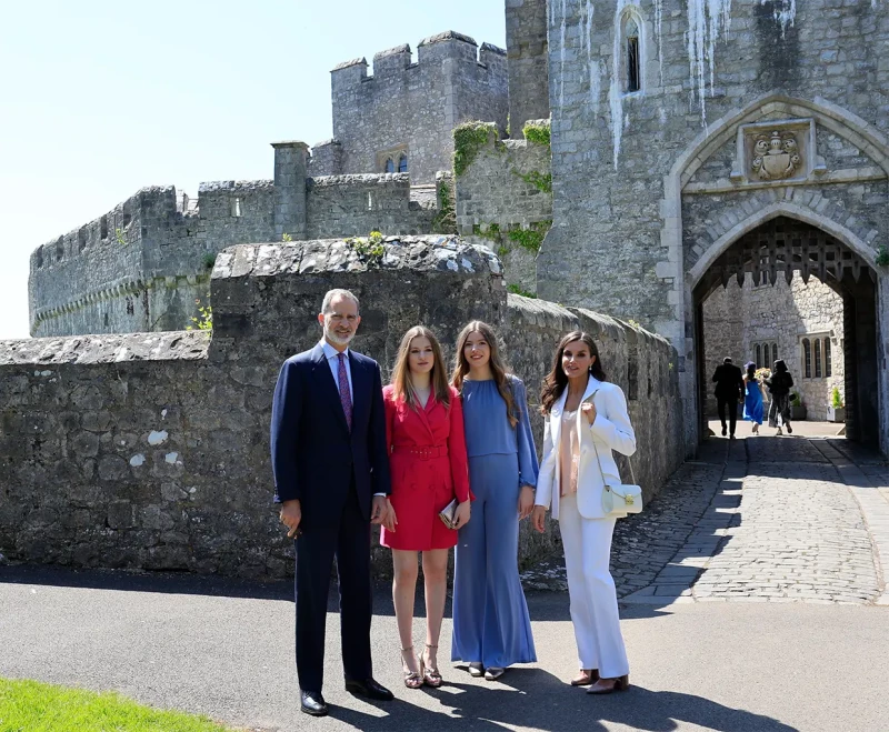 El rey Felipe VI, la reina Letizia, la princesa Leonor y la infanta Sofía posan delante de la entrada a un castillo en Gales