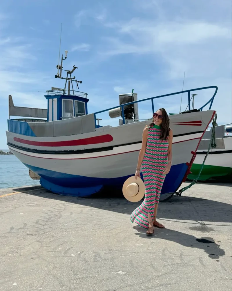 Paz Padilla posando delante de una barca de madera en Portugal.