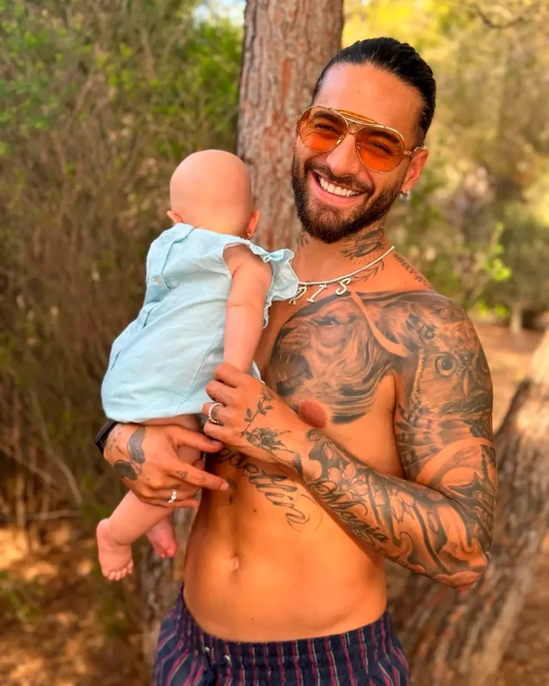 Maluma sonriente con su hija en brazos