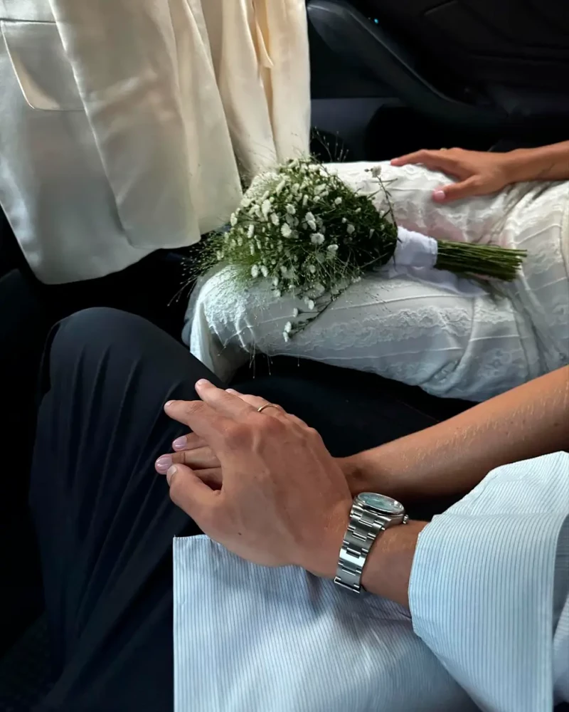 Las manos de los novio entrelazadas junto al ramo de la novia durante la preboda