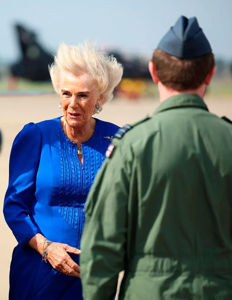 Camilla Parker Bowles en una pista de aterrizaje de la RAF, con los pelos de punta