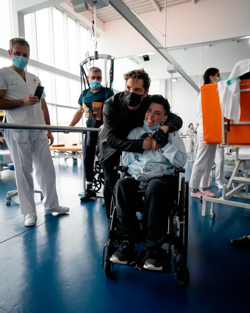 David Bisbal abrazando a una joven en silla de ruedas.