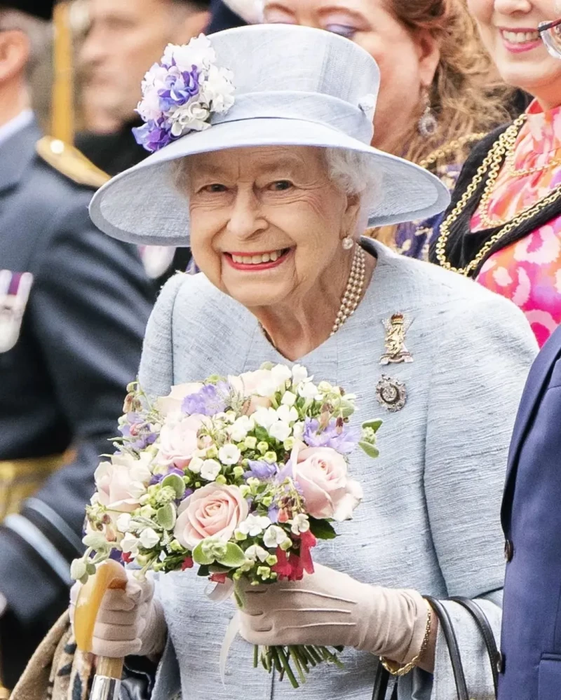 Isabel II llevando un ramo de flores.